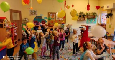 grupa dzieci bawiąca się balonami